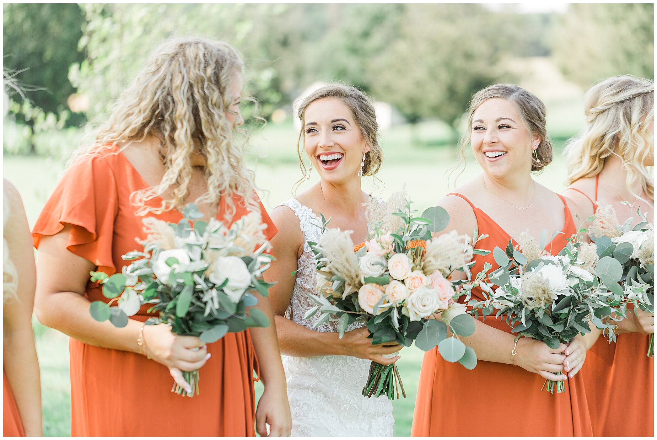 bride laughs with bridesmaids during portraits 