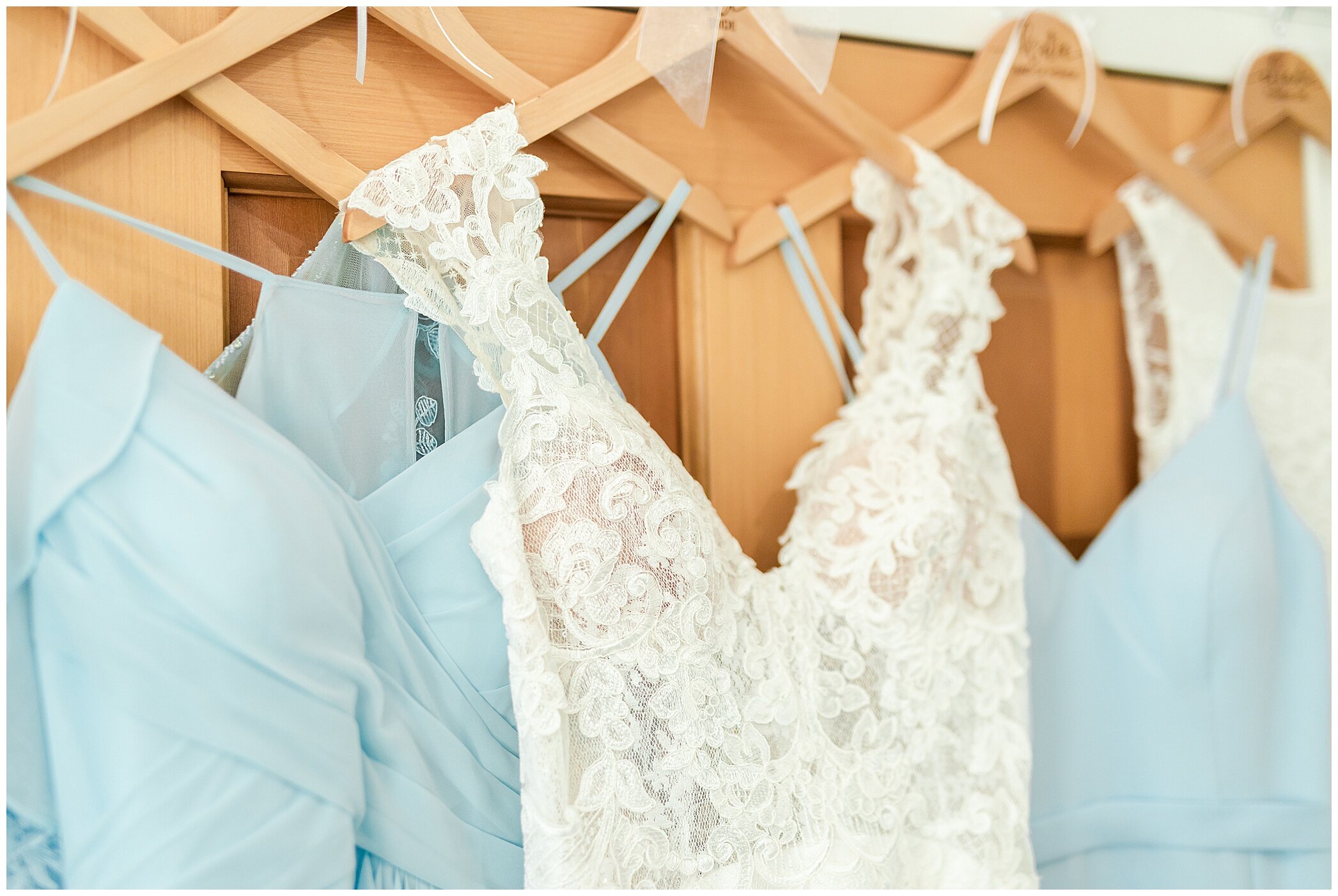 bride's gown hangs with light blue bridesmaid gowns