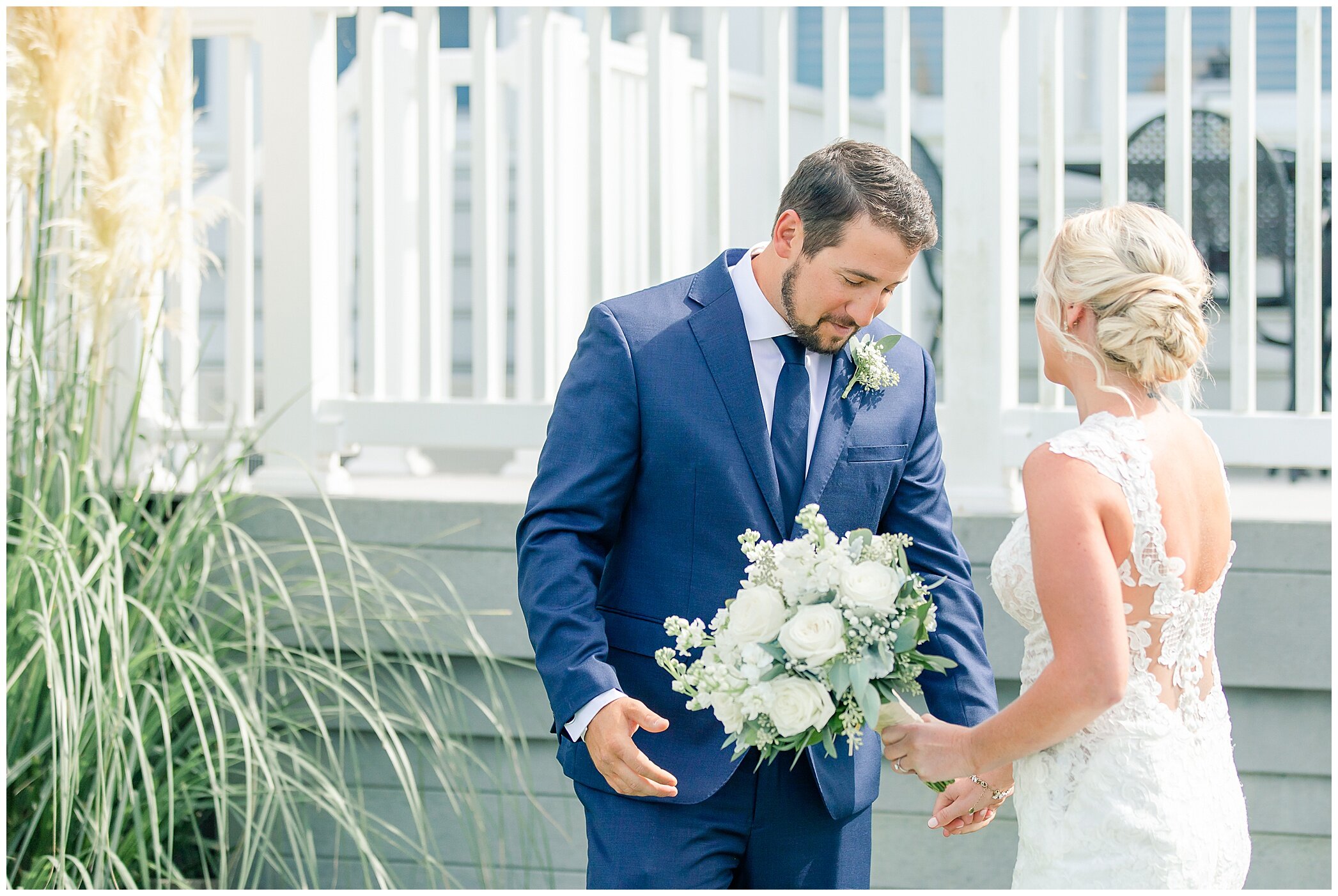groom in navy suit cries during first look with bride