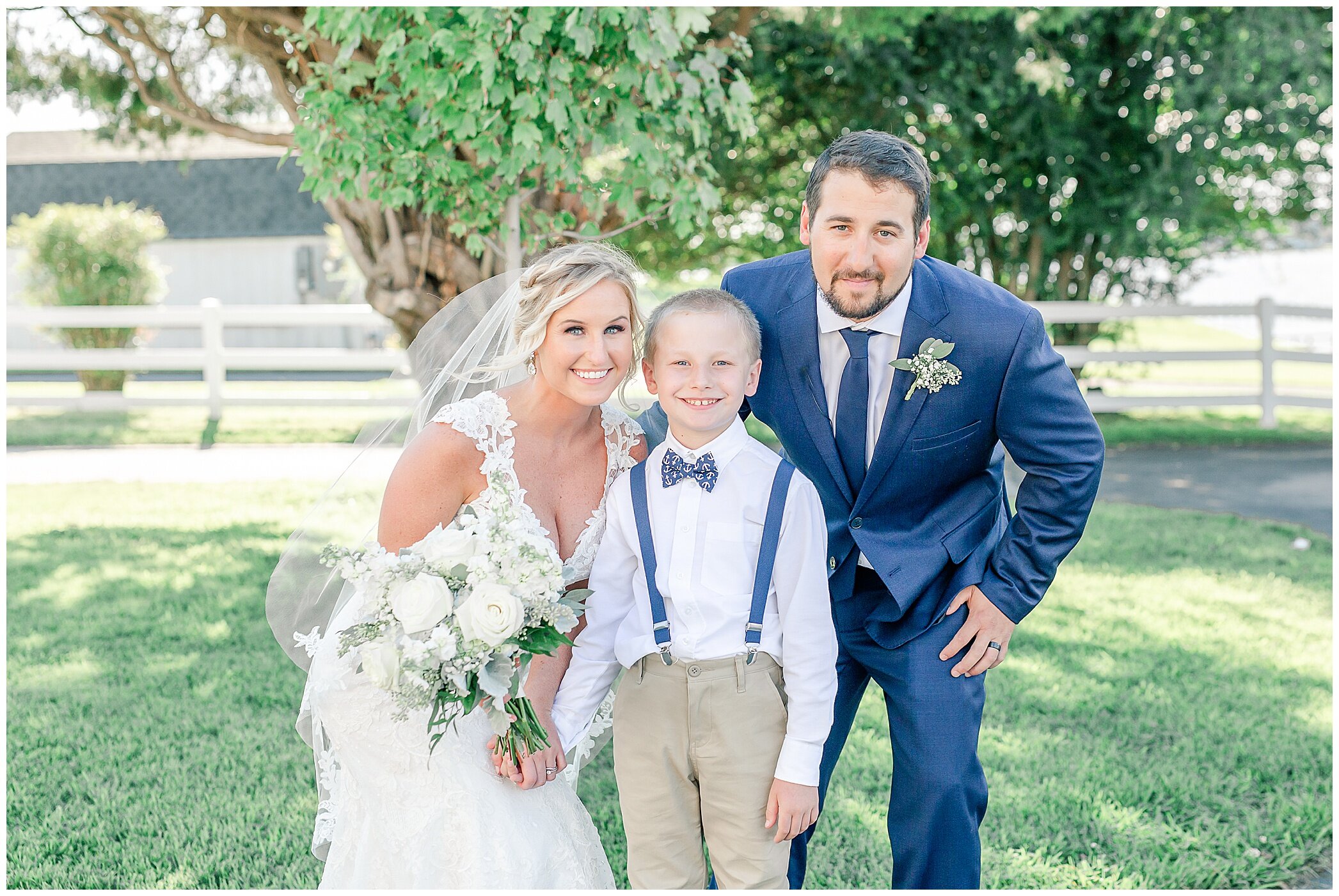 bride and groom pose with ring bearer