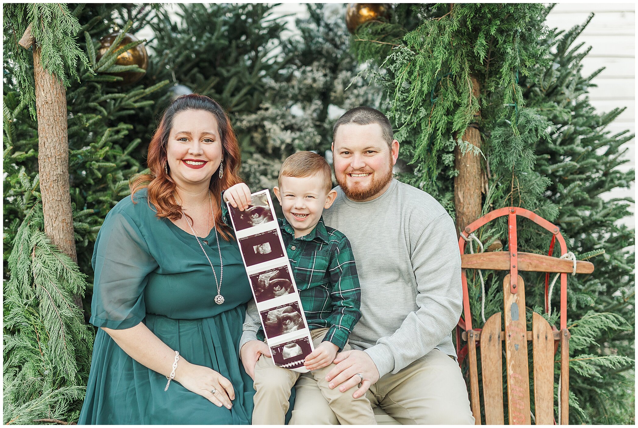 parents hold ultrasound photo with son during Christmas mini sessions with Ryann Winn Photography at Fleur de Fou