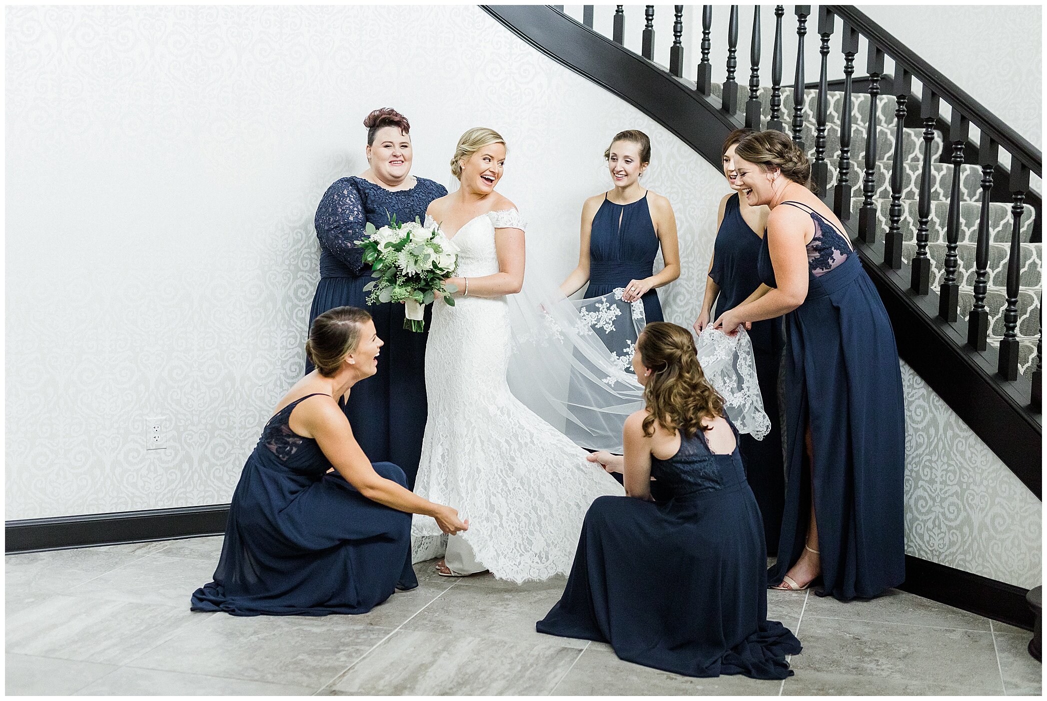 bridesmaids in navy gowns help bride prepare for wedding