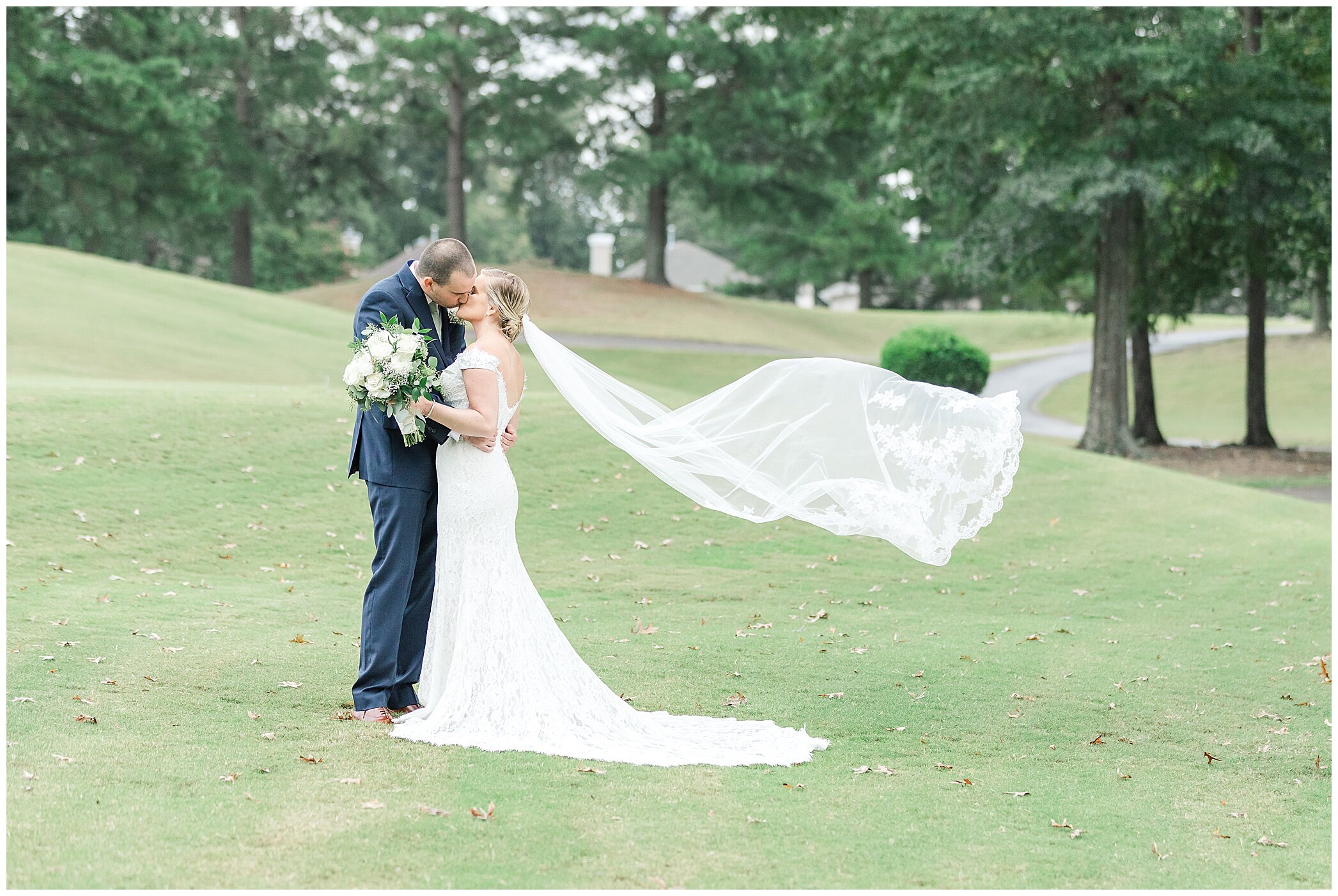 bride and groom kiss at Kiln Creek Golf Club and Resort with veil floating