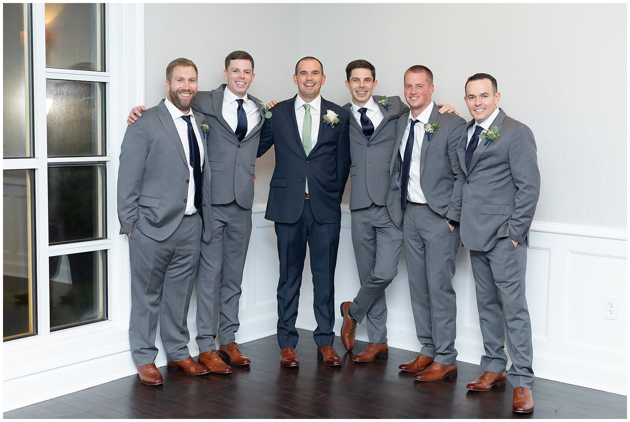 groom poses with groomsmen at Newport News VA wedding reception