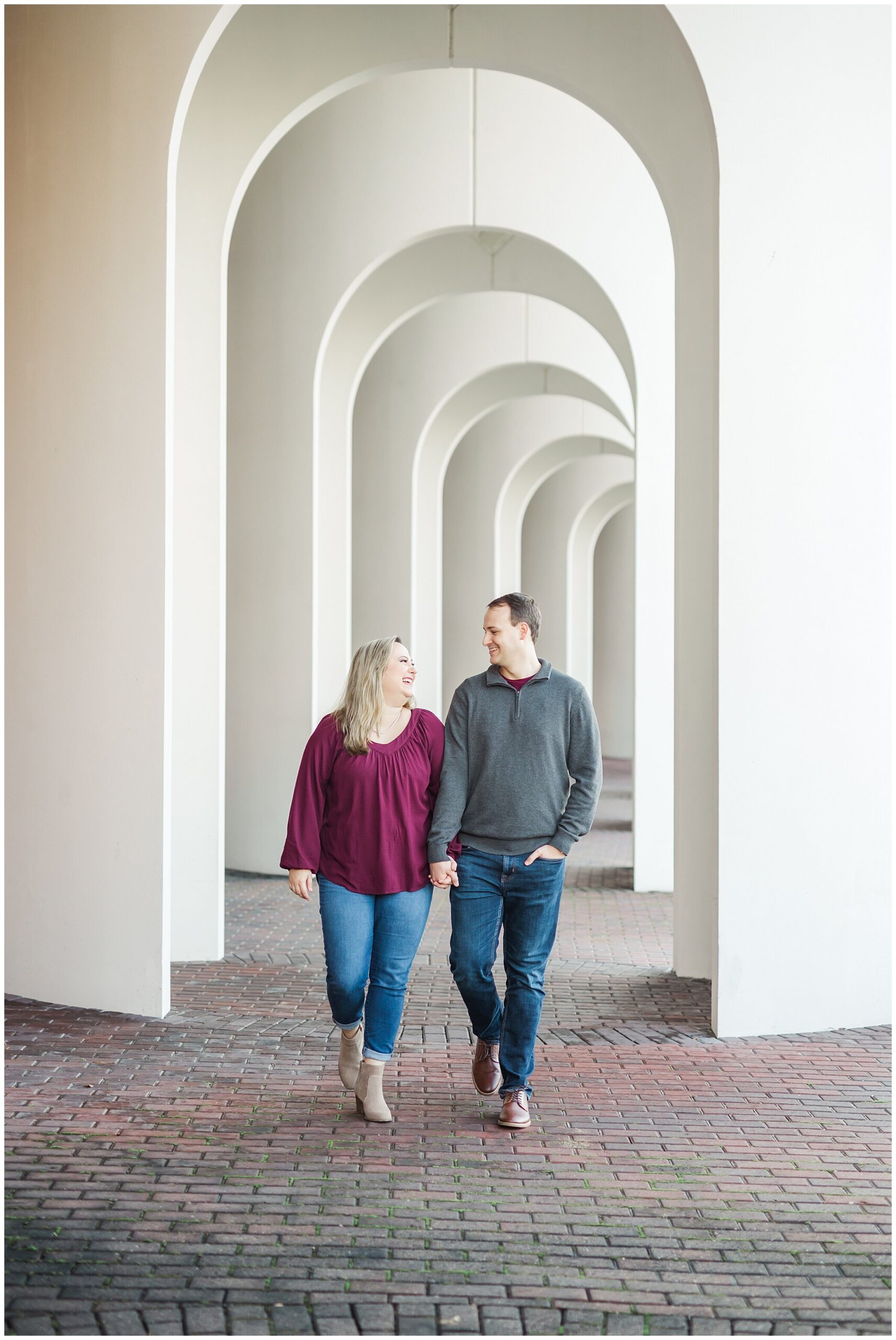 engaged couple walks through archway at Christopher Newport University