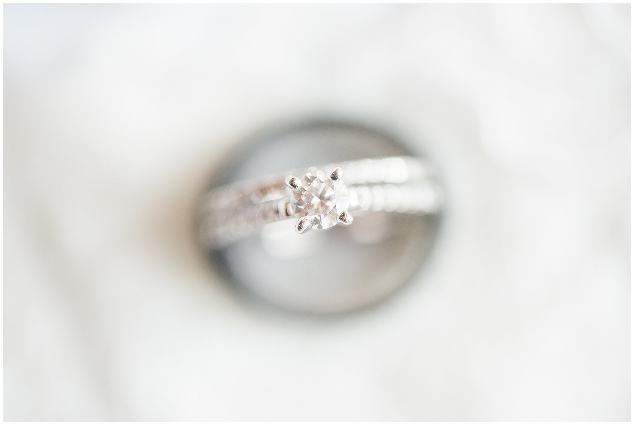 wedding ring rests on lace of wedding gown 