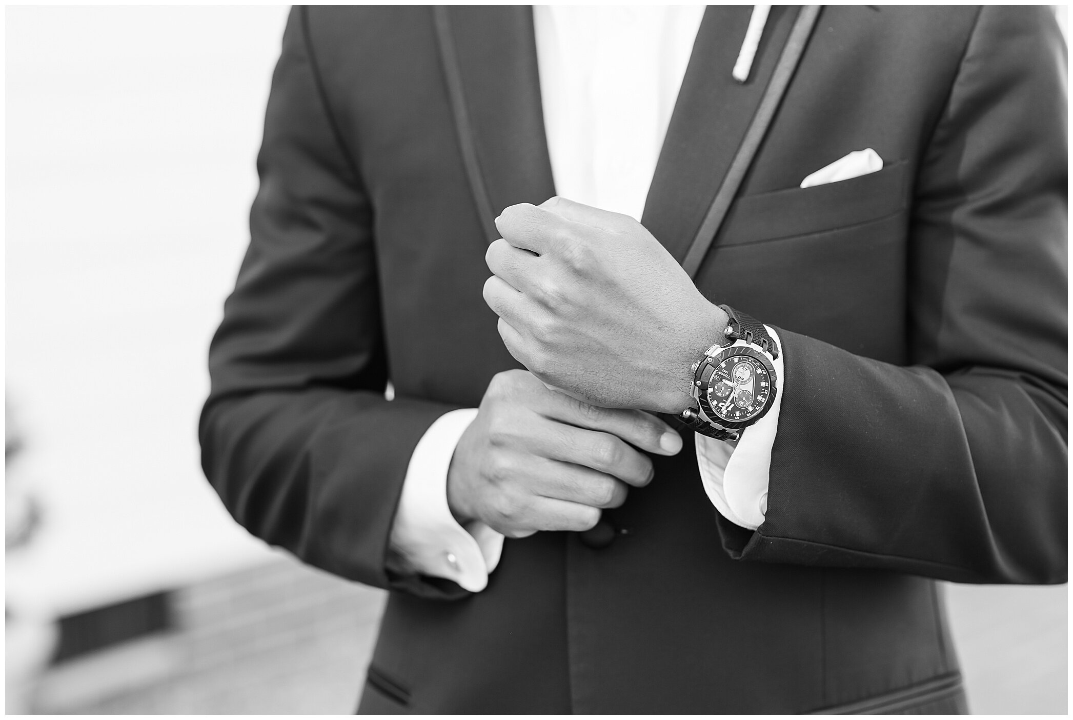 groom adjusts cufflink and watch during morning of wedding prep