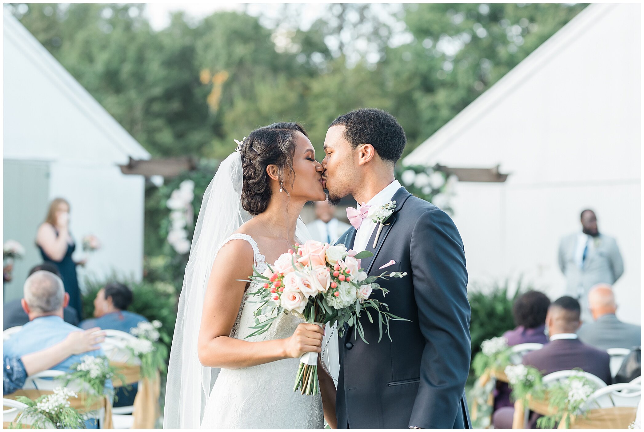 newlyweds kiss at the end of the aisle