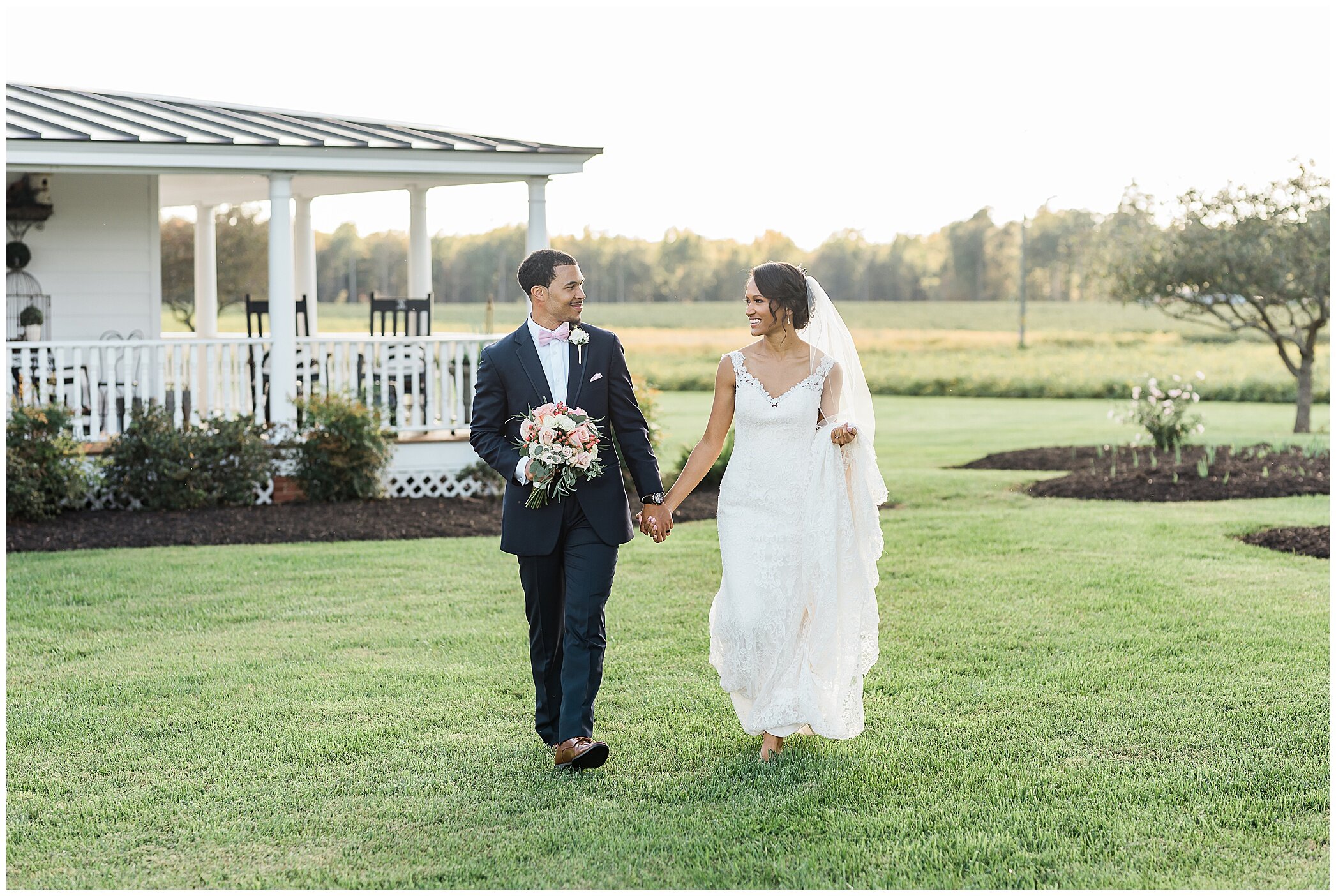 newlyweds walk by farm house at The Barns at Timberneck